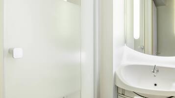 A bathroom with a white sink, a mirror, and a towel rack.