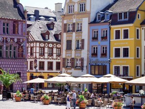 A European-style café with outdoor seating, a sign for 'Guillomé,' and traditional architecture. - ibis budget Mulhouse Centre Gare (Mulhouse)