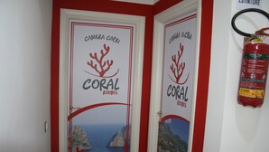Twee deuren met de tekst 'Coral Rooms', een rode omlijsting en een koraalafbeelding.