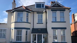 A two-story building with a bay window on the first floor, a front door, and a number '50' on the wall. - Hotel 50 (Bournemouth)