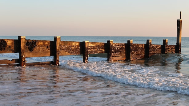 A concrete pier extending into calm waters with waves gently lapping at its base. - Hotel 50 (Bournemouth)