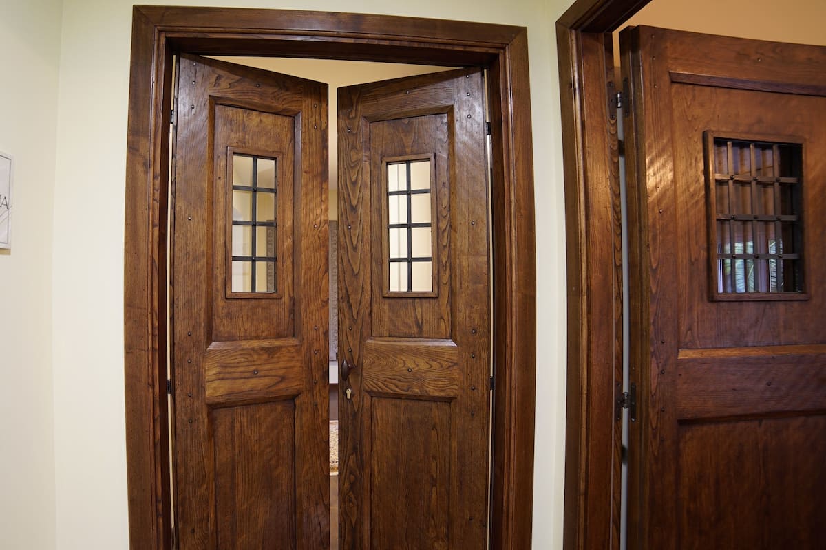 A set of wooden double doors with glass panels and a metal handle.