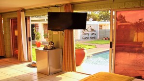 A room with a TV, a small table with a coffee pot, and a sign reading "Berry Bliss Guest House". - Berry Bliss Guest House (Gaborone)