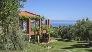 A modern house with a red roof, large windows, and a view of the sea. - Kopana Resort (Kassandra)