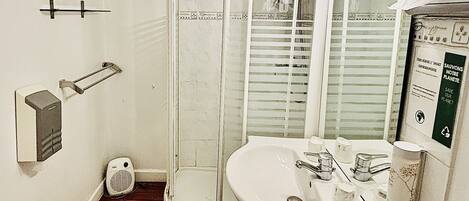 Un baño con ducha, inodoro, lavabo y espejo.