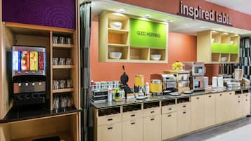 A breakfast bar with labeled storage for utensils, bowls, and plates, and a coffee machine.