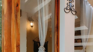 A wooden door with a mirror reflecting a staircase and a hanging towel. - Hotel Tunich Naj (Valladolid)