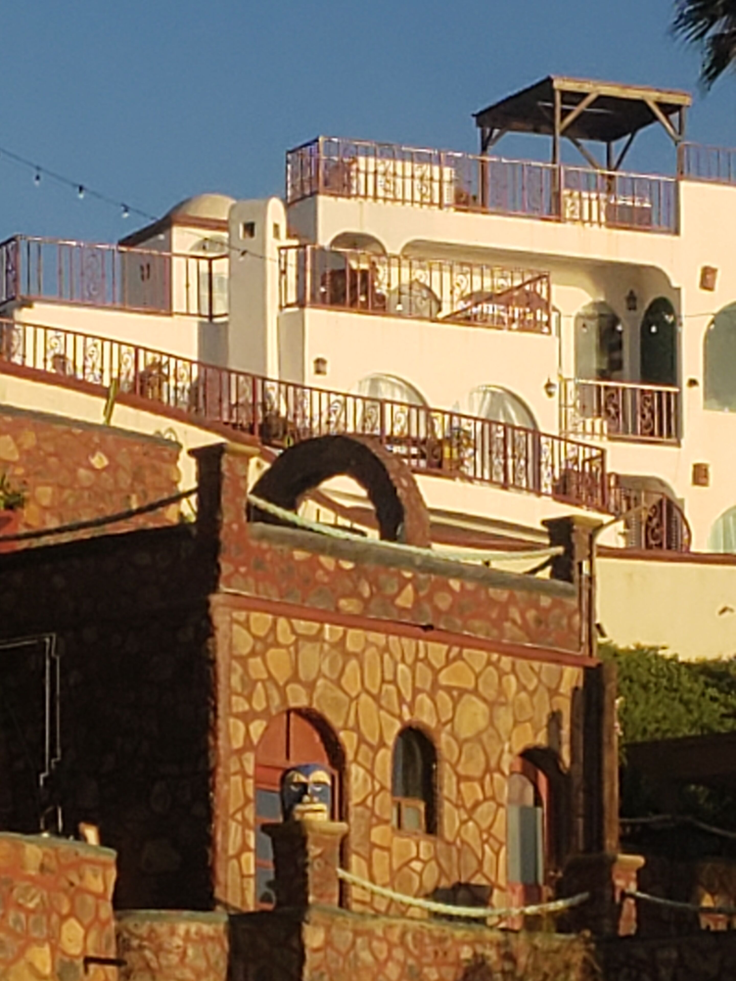 A multi-story building with a stone facade, balconies with railings, and arched windows.