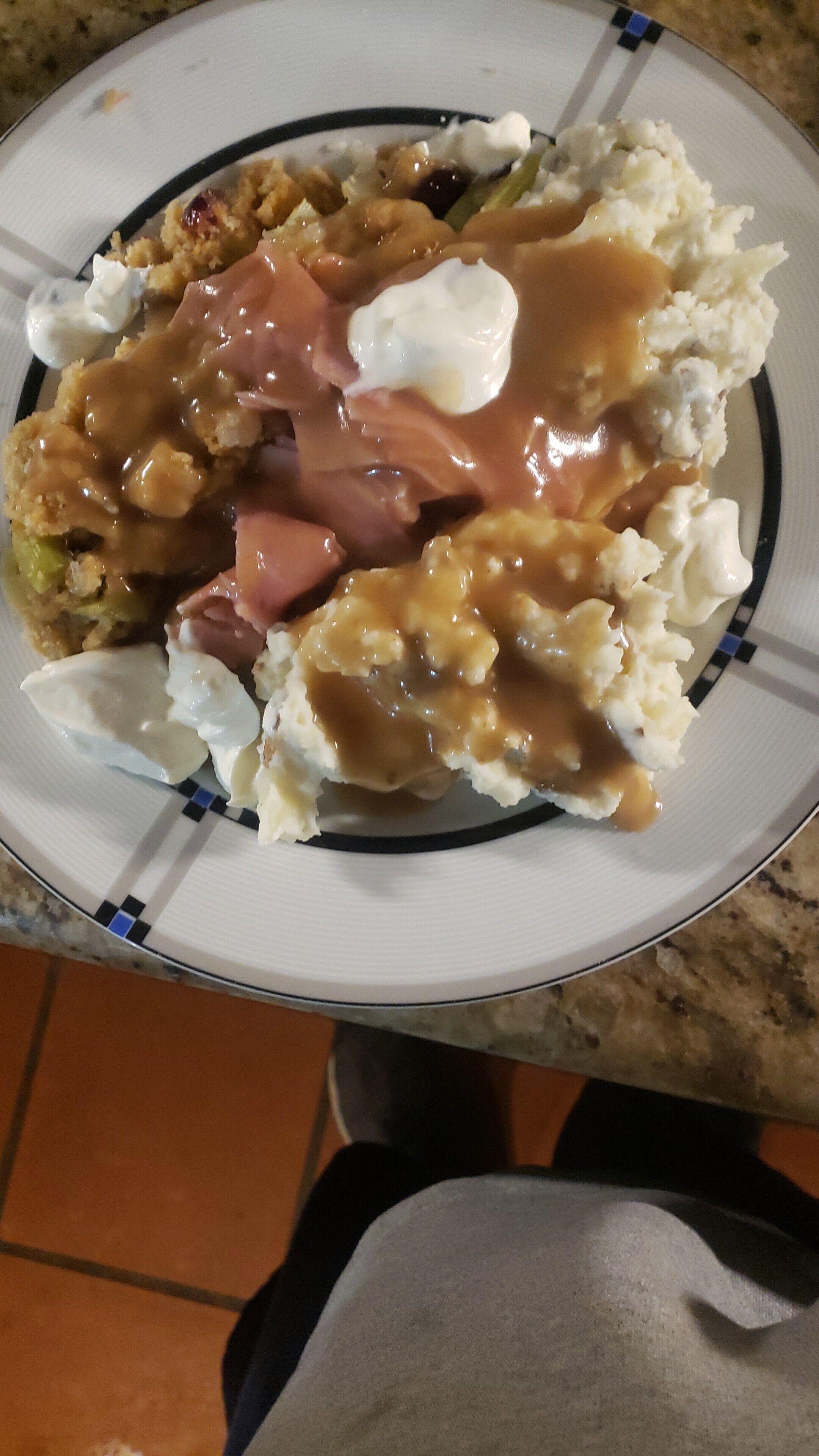 A plate with mashed potatoes, gravy, and a piece of meat.