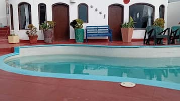 Relax by the serene pool surrounded by lush greenery and a unique architectural style.