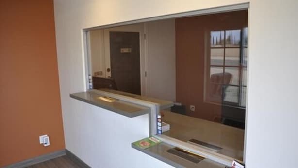 A room with a window, a door, and a small shelf with items on it. - Motel 6 on Maple (Hesperia)