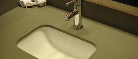 A bathroom sink with a chrome faucet and a towel dispenser.