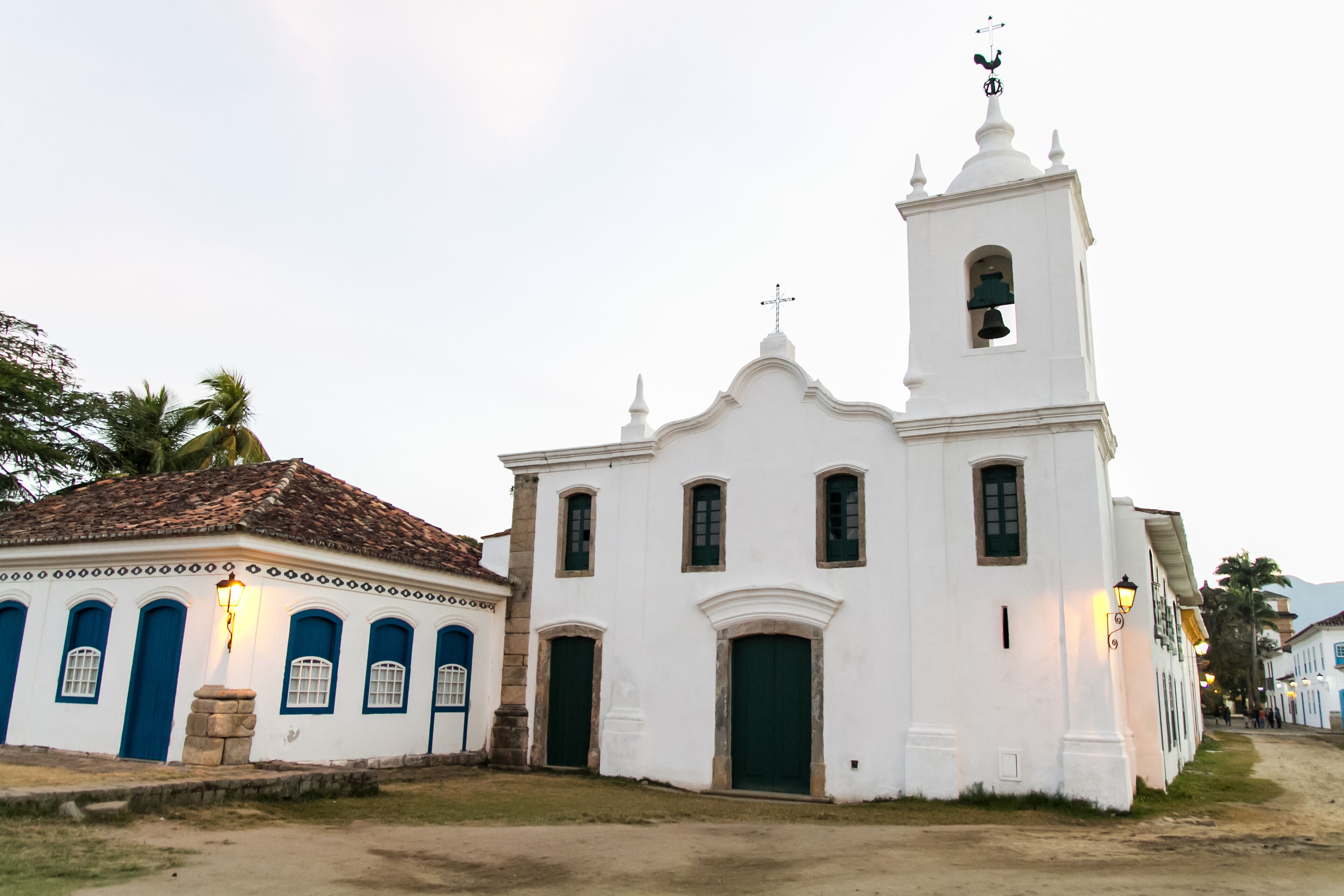 A white church with a bell tower and blue doors.