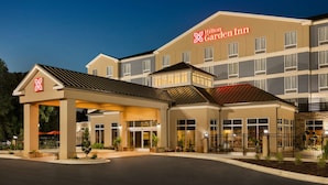 Un hotel Hilton Garden Inn con un diseño moderno, que presenta una entrada cubierta y varios pisos.