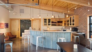 A modern bar with a wooden ceiling, bar stools, and a chalkboard menu. - Hampton Inn & Suites-Seattle Woodinville WA (Woodinville)