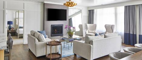 Una sala de estar moderna con dos sofás, un televisor, una chimenea y un comedor.