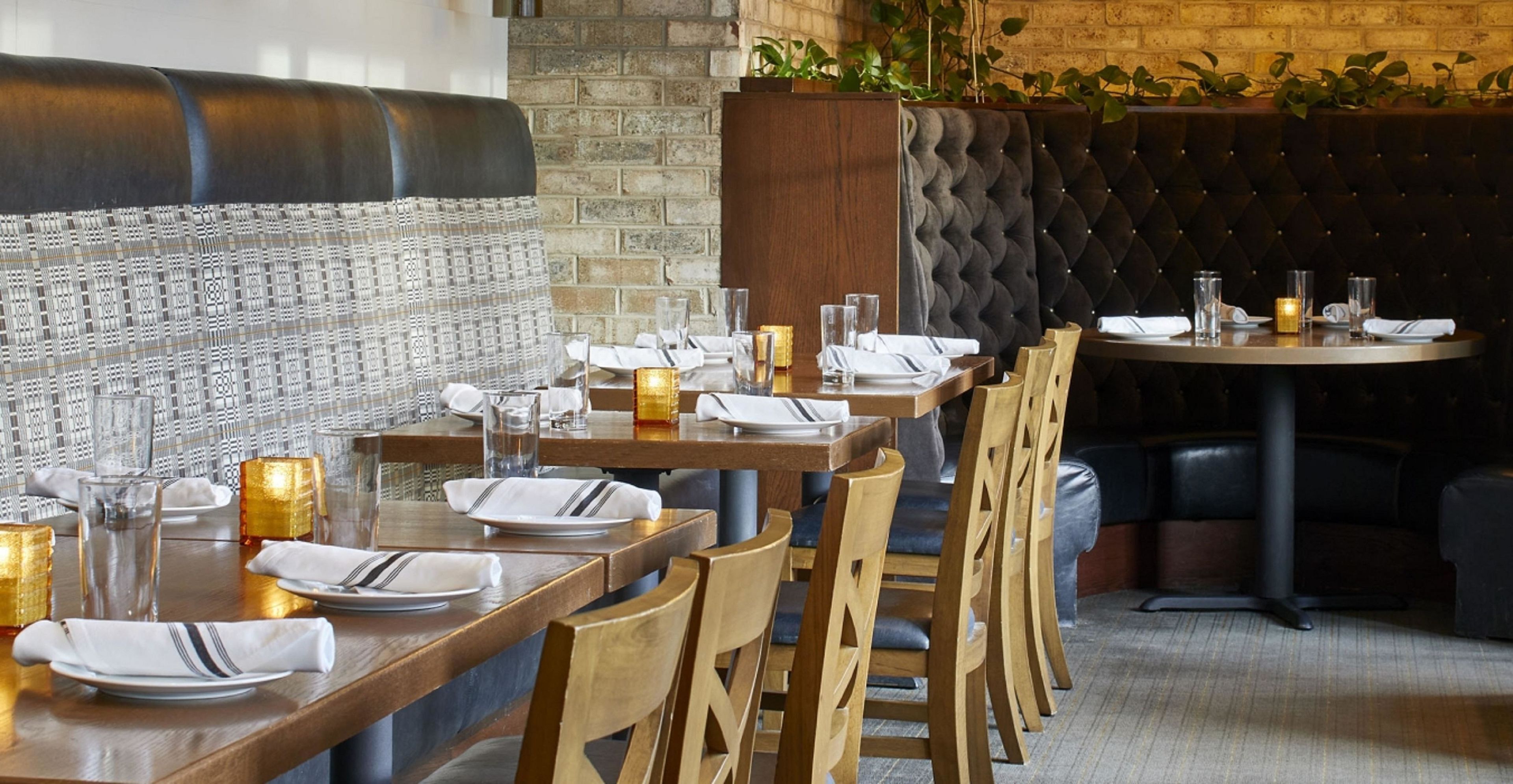 Un restaurante con mesas y sillas de madera y una pared de ladrillo.