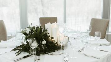 A table set for a formal event with candles, glassware, and a floral centerpiece.