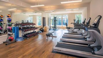 Ein Fitnessstudio mit Laufbändern, Kraftgeräten und verschiedenen Trainingsbällen.
