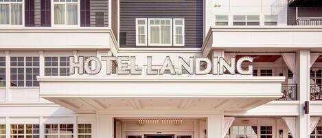 Ein Hotel mit auffälligem Eingang, einem draußen abgestellten Fahrrad und einem Schild, auf dem 'HOTEL LANDING' steht.