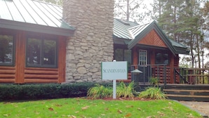 A Scandinavian-style building with a stone facade, wooden exterior, and a sign indicating its name. - The Ridge (Gaylord)