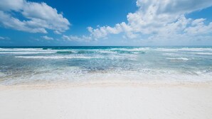 Uma praia com céu limpo e ondas.