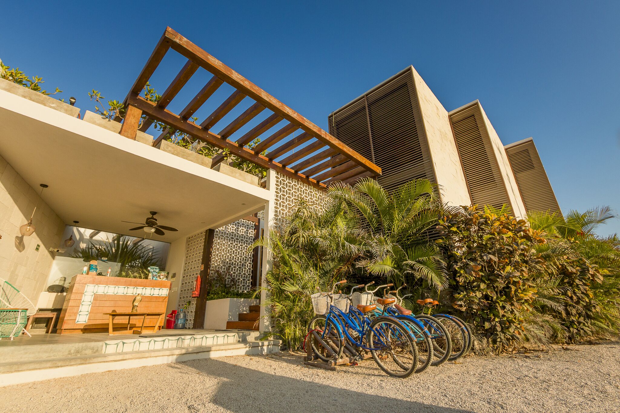 A modern building with a covered outdoor area, a staircase, and bicycles parked outside.