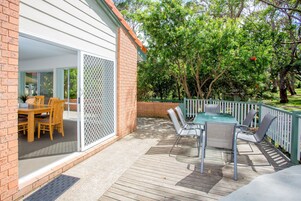 Eine Terrasse mit Holzdeck, einem Tisch und Stühlen sowie einem Pool.