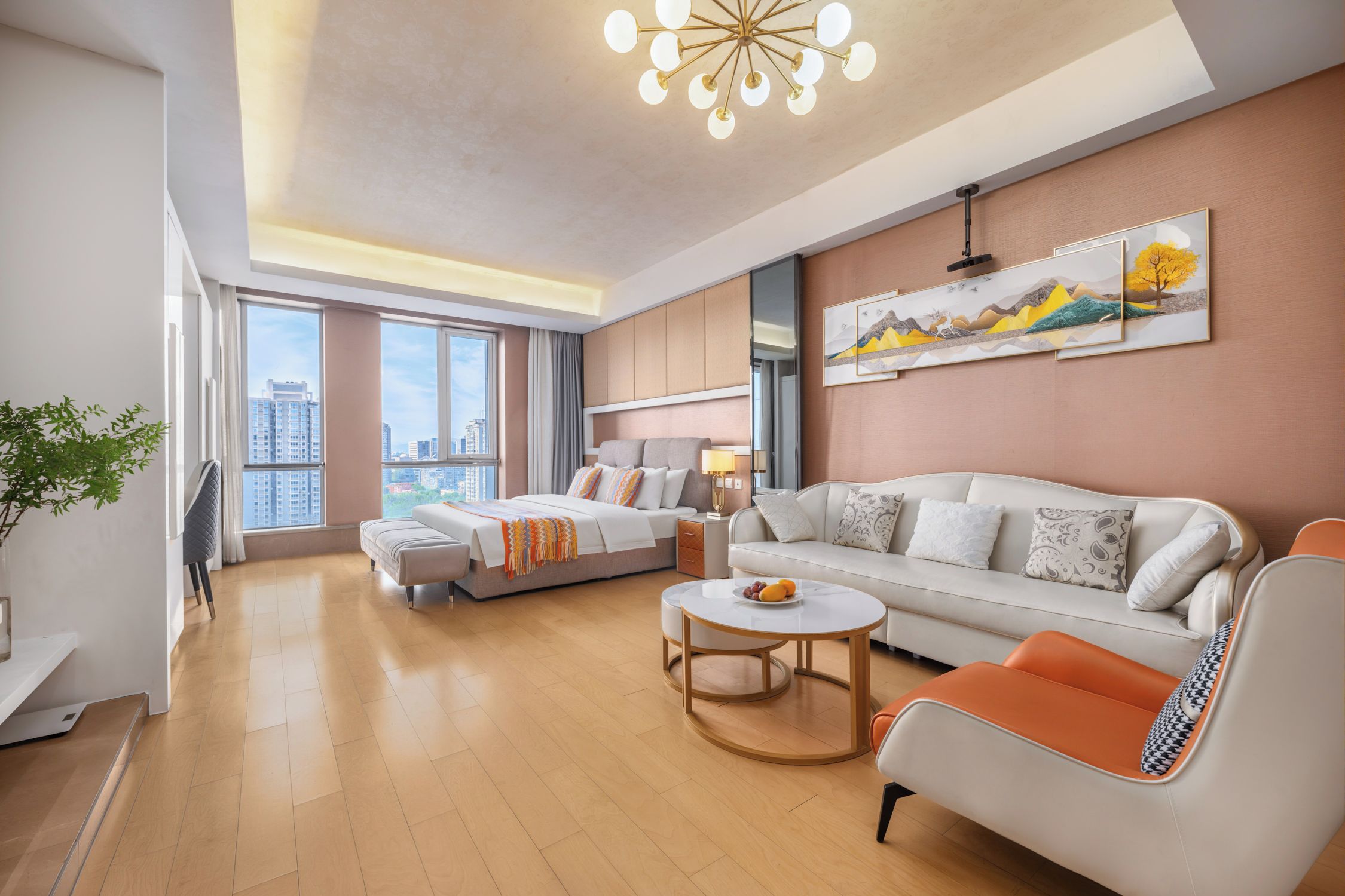 Een moderne hotelkamer met een groot bed, een bank, een bijzettafeltje en een uitzicht op de stadsbelangrijkste punten door grote ramen.
