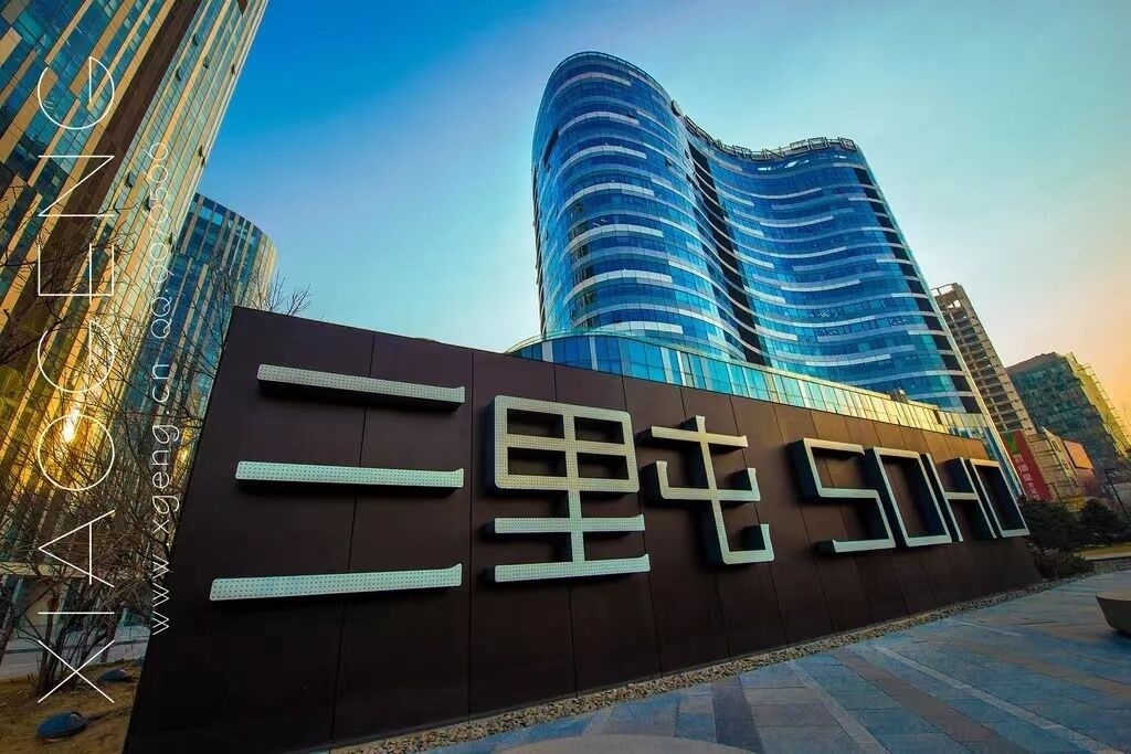 Un edificio moderno con fachada curva y un letrero destacado con letras grandes y audaces.