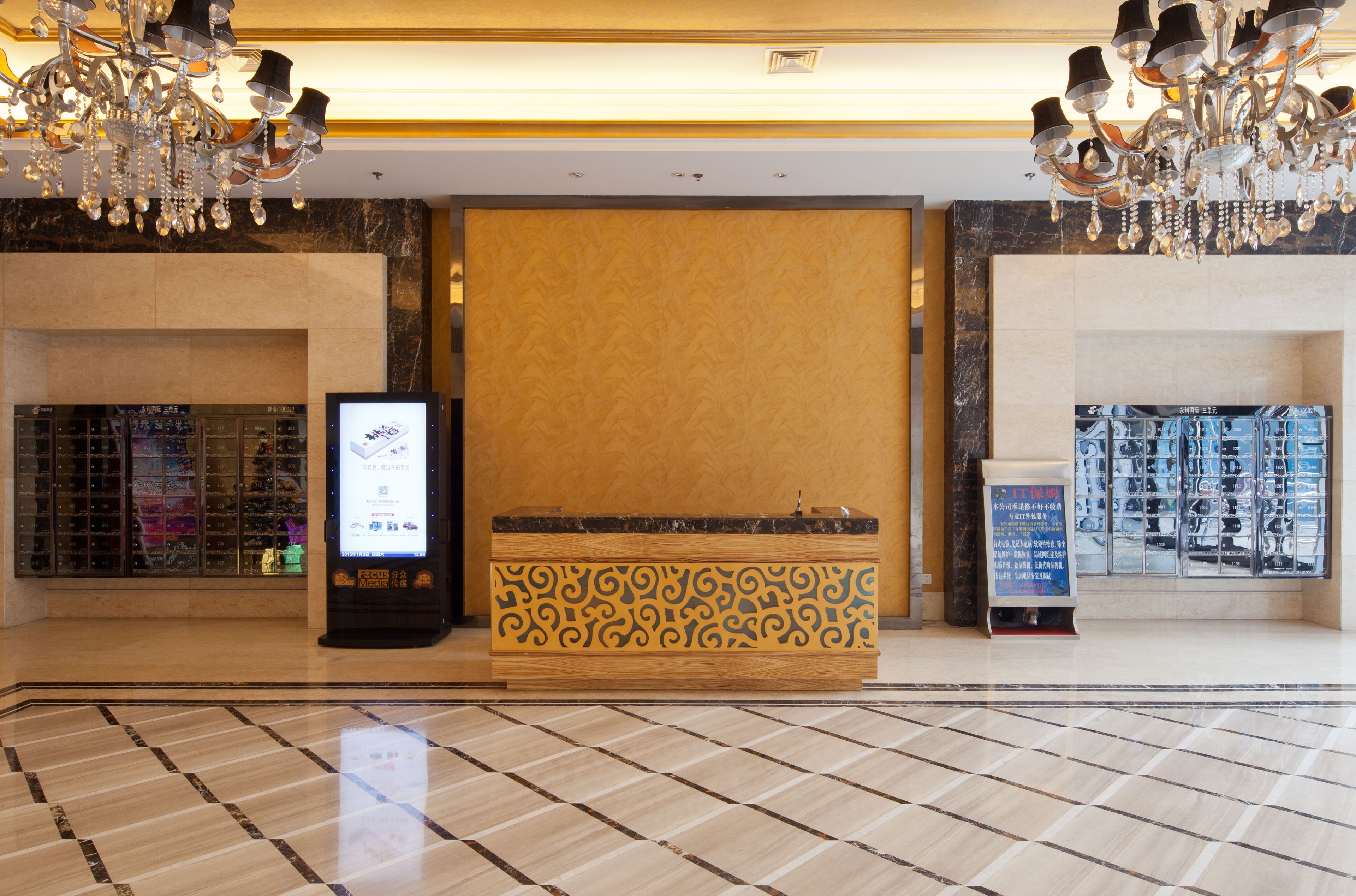 A lobby with a reception desk, a digital screen, and a display of items.