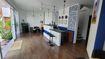 Une cuisine moderne dotée d’un bar, de planchers en bois et de ventilateurs de plafond.