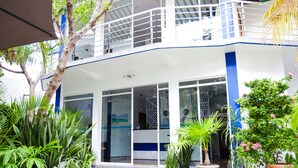 A two-story building with a balcony, large windows, and potted plants. - Palm Residence (Rasdhoo)