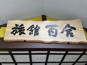 A wooden sign with Chinese characters. - Ryokan Yuri (Yufu)