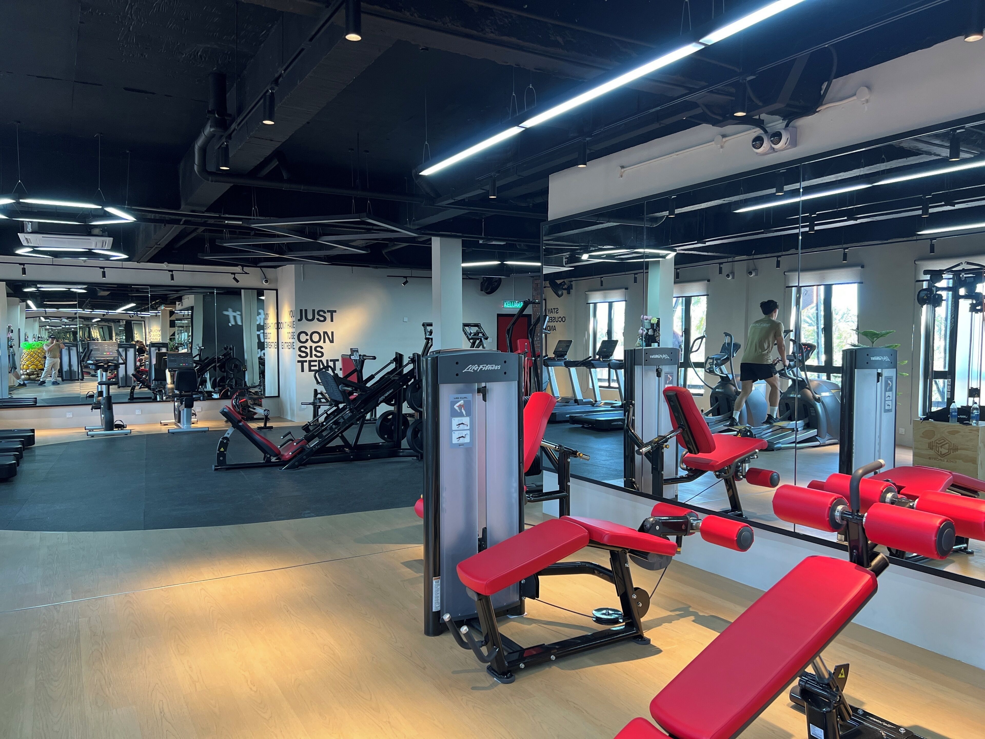 A gym with exercise equipment, treadmills, and a mirror.