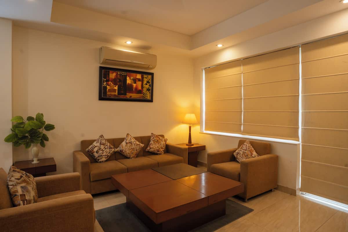 A modern living room with a sofa set, a coffee table, a lamp, and an air conditioning unit.