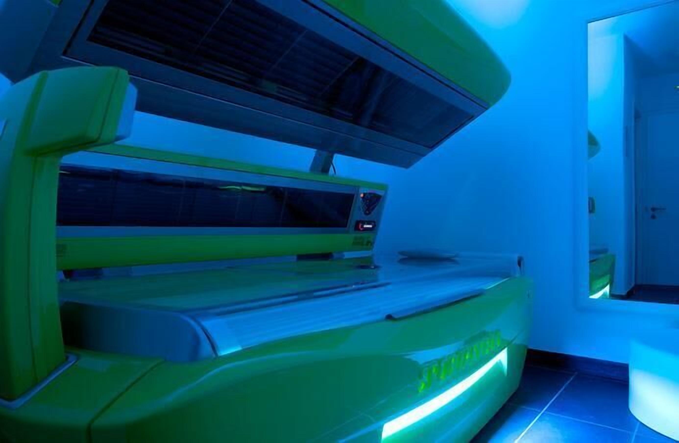 A tanning bed with a control panel and a ventilation system.