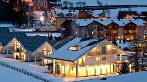 A snow-covered residential area with modern houses featuring large windows and solar panels. - Muu Village (Folgaria)