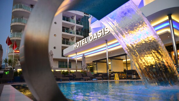 A hotel named "HOTEL OASIS" with a pool area and lounge chairs. - Oasis Otel (Marmaris)