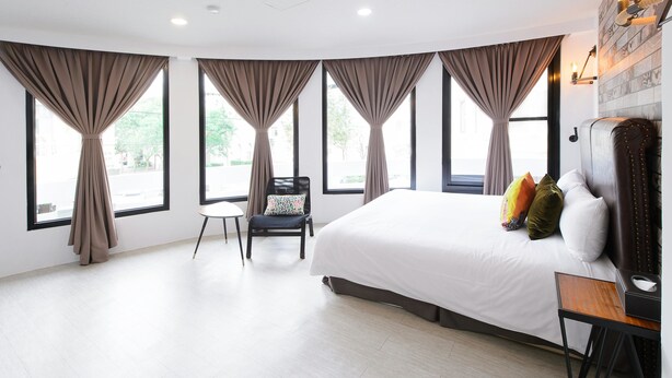 A modern hotel room with a large bed, a chair, and a desk. - Live in the happiness (Zhushan)