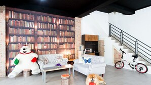 A modern living room with a bookshelf, a sofa, a coffee table, a dog, a bicycle, and a staircase. - Live in the happiness (Zhushan)