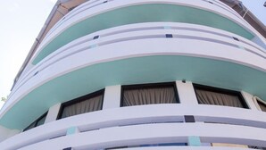 A multi-story building with a curved facade, large windows, and a visible balcony. - Live in the happiness (Zhushan)