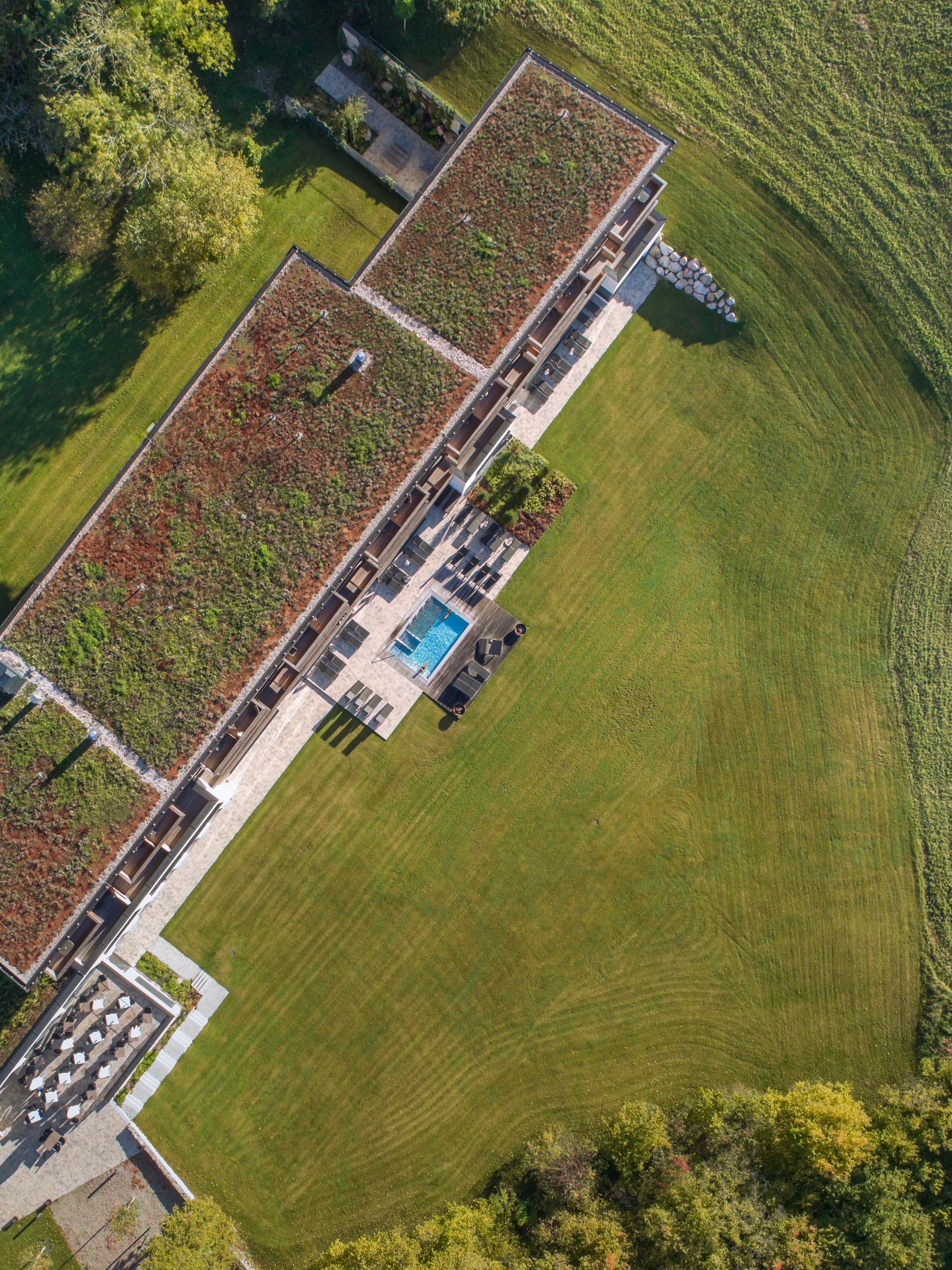 Vue aérienne d’un hôtel moderne doté d’un jardin sur le toit, d’une piscine et d’une pelouse bien entretenue.