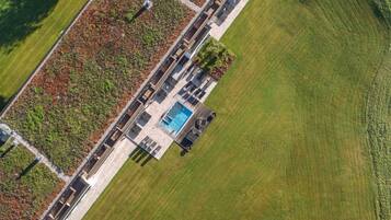 Vue aérienne d’un hôtel moderne doté d’un jardin sur le toit, d’une piscine et d’une pelouse bien entretenue.