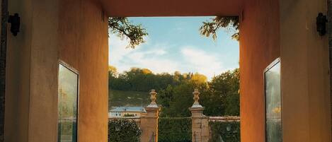 Una entrada arqueada con vistas a un jardín y una fuente.