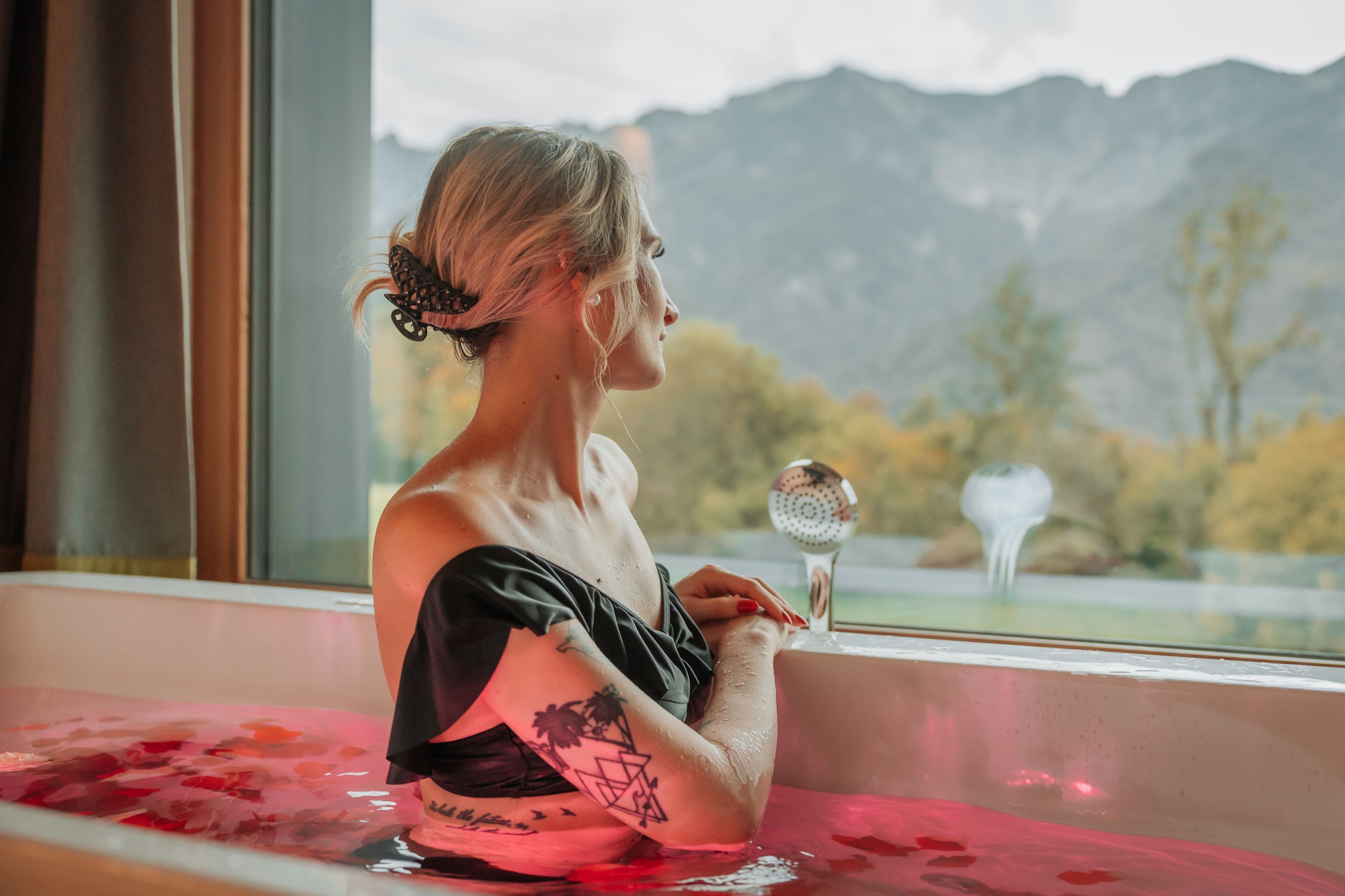 A person in a bathtub with a mountain view.