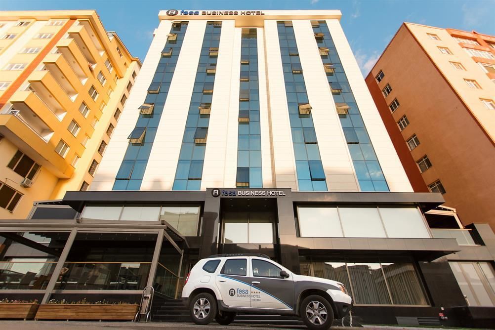 Un edificio alto con un cartel que dice 'Fesa Business Hotel' en la parte superior.