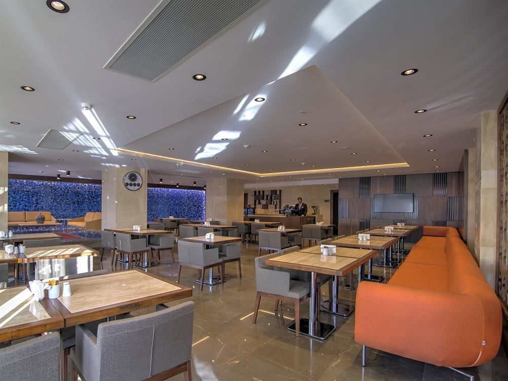 A modern restaurant with a bar area, seating arrangements, and a counter.