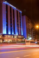 A business hotel with a modern facade and illuminated signage.
