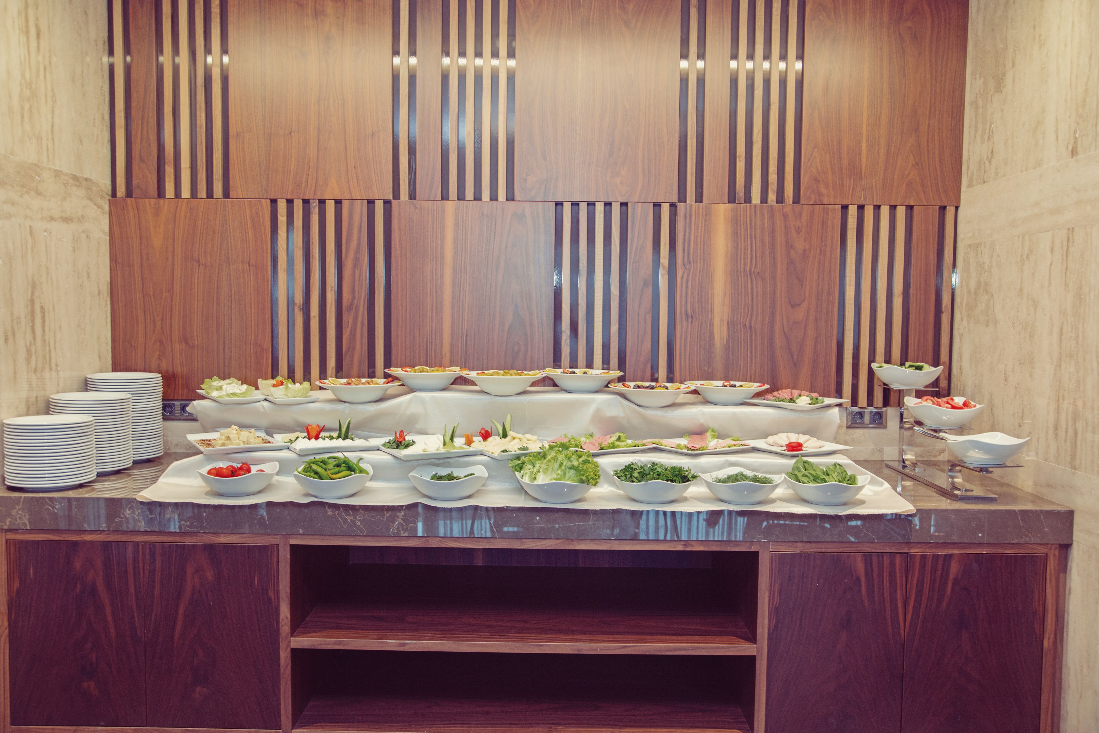 Una mesa de mármol con varios alimentos y tazones en un bufé.